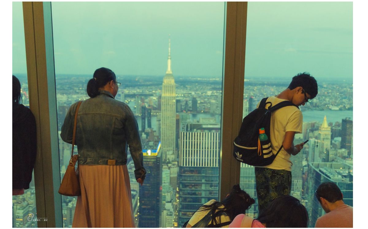 People watching the Empire State from the indoor observation deck
